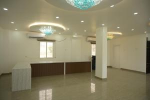 a large room with white walls and blue chandeliers at Hotel Surya Inn in Khagaul