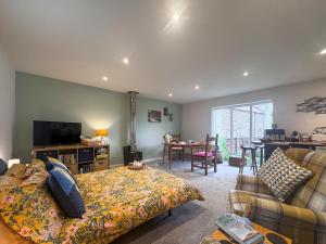 a bedroom with a bed and a living room at The Other House in Briston