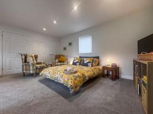 a bedroom with a bed and a couch and a tv at The Other House in Briston