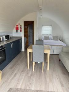 a kitchen and living room with a table and a bed at Braehead Pods in Forth