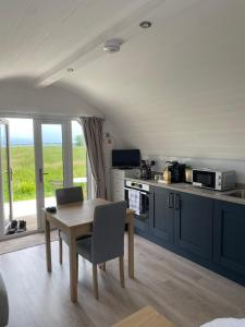 a kitchen with blue cabinets and a table with chairs at Braehead Pods in Forth