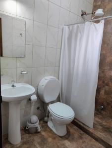 a white bathroom with a toilet and a sink at Haus Eldorado in Eldorado