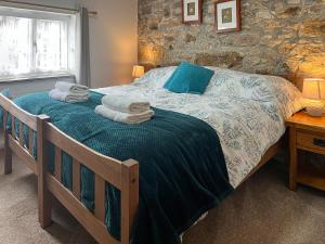a bedroom with a bed with towels on it at Mum's Cottage - Uk52136 in Henwood