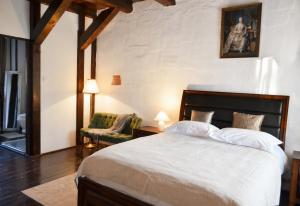 a bedroom with a large bed and a chair at Casa Huber in Cîrţa