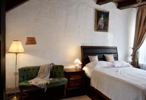a bedroom with a bed and a green chair at Casa Huber in Cîrţa