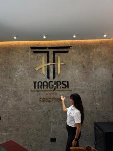 a woman is standing in front of a sign at Hotel Tragjasi in Orikum