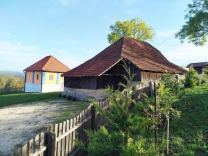 an old house with a wooden fence in front of it at Domaćinstvo Nikolić-Milicevo Selo in Požega