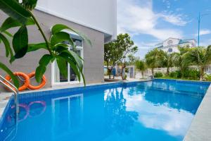 a swimming pool in front of a building at Kegotel Luxury Villa - Bãi Tắm Long Cung in Vung Tau
