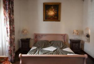 a bed in a bedroom with two lamps and a picture on the wall at Casa Huber in Cîrţa