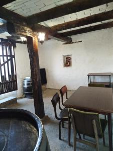 a room with a table and chairs and a tub at Domaćinstvo Nikolić-Milicevo Selo in Požega