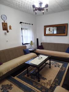 a living room with two couches and a coffee table at Domaćinstvo Nikolić-Milicevo Selo in Požega