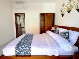 a bedroom with a large white bed with pillows at Mesari Jinah Villa 1 - 2BR Private Pool Near Melasti Beach Uluwatu in Uluwatu