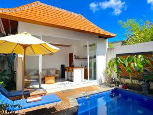 a house with a swimming pool and an umbrella at Mesari Jinah Villa 1 - 2BR Private Pool Near Melasti Beach Uluwatu in Uluwatu