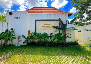 a white building with a welcome sign in front of it at Mesari Jinah Villa 1 - 2BR Private Pool Near Melasti Beach Uluwatu in Uluwatu