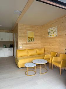 a living room with a yellow couch and two tables at Splav Zoi Perucac in Aluga
