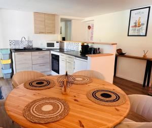 a kitchen with a wooden table with chairs and a kitchen at Le Manana in Crozon