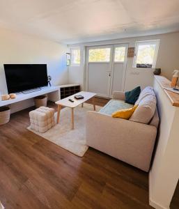 a living room with a couch and a flat screen tv at Le Manana in Crozon