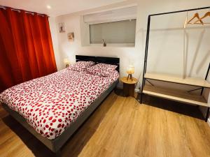a bedroom with a bed with a red comforter at Le Manana in Crozon