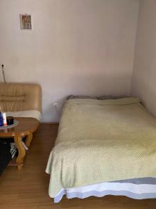 a small bedroom with a bed and a table at Drinska oaza in Zvornik