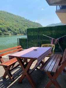 a picnic table and two chairs next to a river at Drinska oaza in Zvornik +4 photos