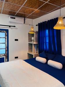 a bedroom with blue curtains and a bed with two pillows at Harsha Villa Dickwella in Dickwella