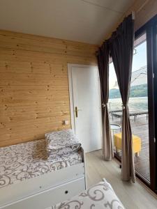 a bedroom with two beds and a large window at Splav Zoi Perucac in Aluga