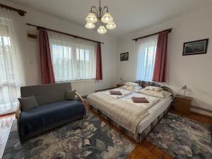 a bedroom with a bed and a chair in it at Flóra Apartmanok in Parádsasvár