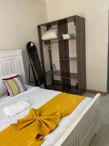 ein Schlafzimmer mit einem Bett mit einer gelben Schleife darauf in der Unterkunft Kitale Comfy in Kitale