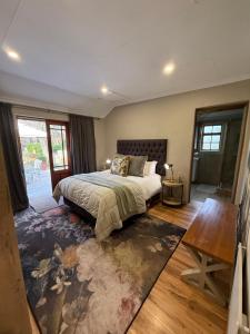 a bedroom with a large bed and a table at Zwartmodder Clarens in Clarens