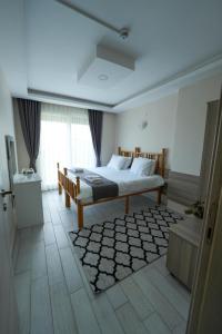 a bedroom with a bed and a large window at İNDAĞ APART AİLE Oteli in Seferihisar