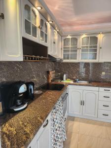 a kitchen with white cabinets and a sink at Apartment Villa al Mare 1 in Shkorpilovtsi