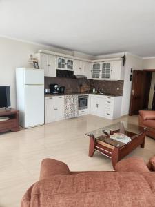 a kitchen with white cabinets and a coffee table at Apartment Villa al Mare 1 in Shkorpilovtsi +27 photos