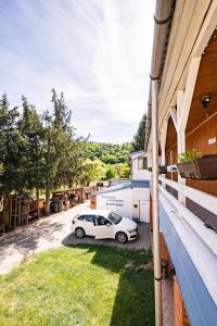 a white car parked on the side of a building at Gyarmati Vendégház Sirok in Sirok
