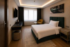 a hotel room with a bed and a desk at T h e V o i d Hotel - Just Steps From Osmanbey Metro Station in Esenyurt