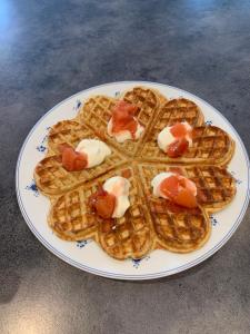 a plate of waffles with bacon and sauce on it at Billingen Seterpensjonat in Skjåk