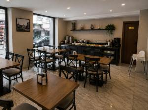 a restaurant with wooden tables and chairs and a kitchen at T h e V o i d Hotel - Just Steps From Osmanbey Metro Station in Esenyurt