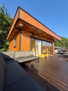 a house with a couch on a wooden deck at Splav Zoi Perucac in Aluga