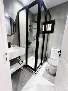a bathroom with a shower and a toilet and a sink at La Casa Residence in Dakar