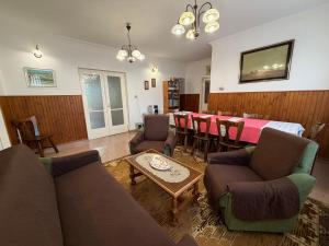 a living room with a long table and chairs at Flóra Apartmanok in Parádsasvár