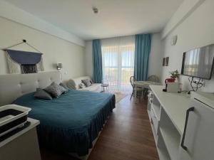 a bedroom with a bed and a living room at Studio Cris Sea View in Blaxy Residence in Douăzeci şi Trei August