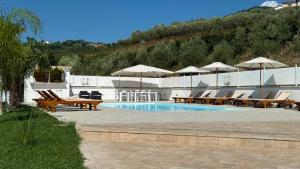 a pool with tables and chairs and umbrellas at Masseria Marotta Appartamento in Santa Paolina
