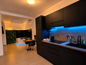 a kitchen with black cabinets and a blue led lighting at Seven Suite SPA in Fiumicino