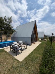 a house with a metal roof and a picnic table at Moobs Sunset Cabins in Batroûn