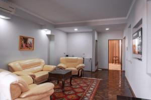 a living room with couches and chairs and a table at Omar Khayyam Hotel in Bukhara