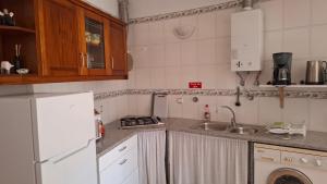 a kitchen with a white refrigerator and a sink at Aljezur Coast Apartment - Villa Luar in Aljezur