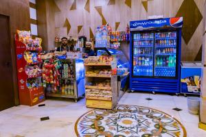 a store with two men standing in a store with drinks at Grand Zowar Hotel - فندق جراند زوار للضيافة السياحي in Medina