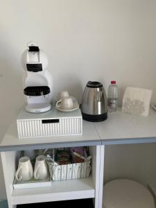a shelf with a coffee maker and other kitchen items at Mgd House in Santa Domenica