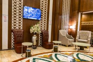 a lobby with a waiting area with chairs and tables at Grand Zowar Hotel - فندق جراند زوار للضيافة السياحي in Medina