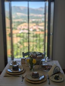 a table with plates of food on a table with a window at Casa de' Vestini in Fossa