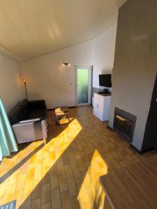 a living room with a couch and a fireplace at Bungalows du Lac de Rabais in Virton